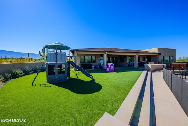 view of play area with a mountain view and a lawn