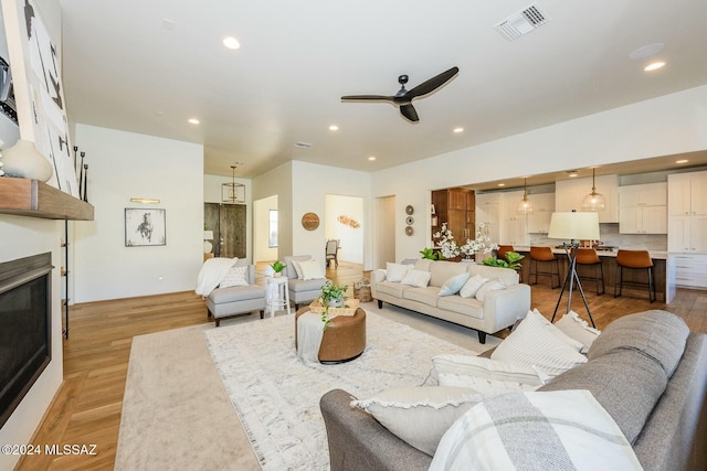 living room featuring ceiling fan and light wood-type flooring