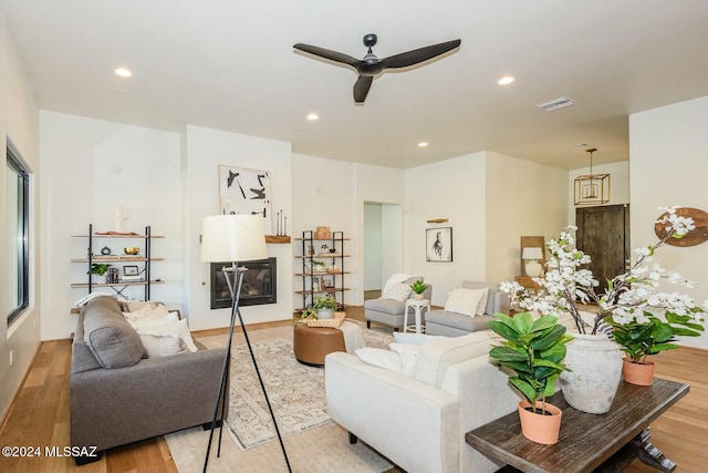 living room with ceiling fan and light hardwood / wood-style flooring