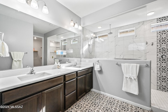 bathroom with tile patterned floors, a tile shower, and vanity