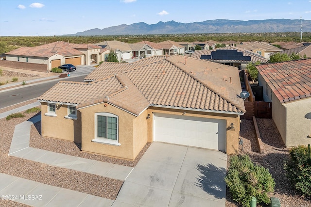 view of front of home with a garage and a mountain view