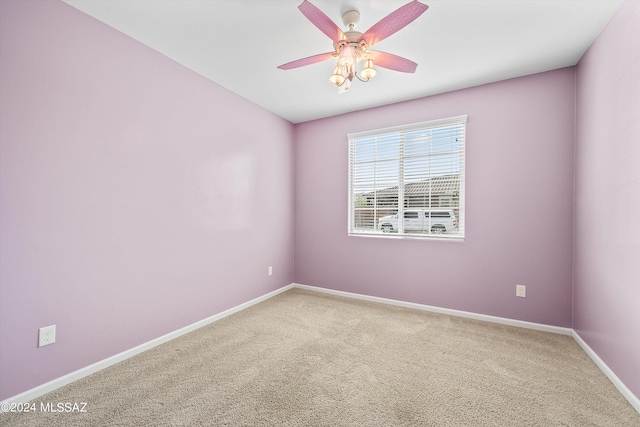 carpeted spare room featuring ceiling fan