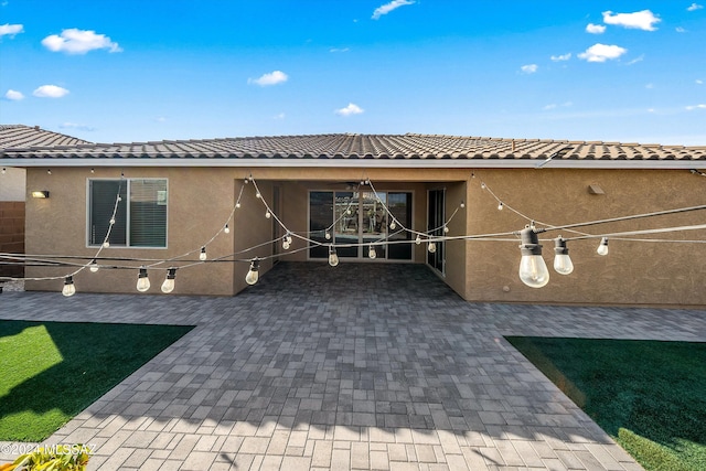 rear view of house featuring a lawn and a patio area