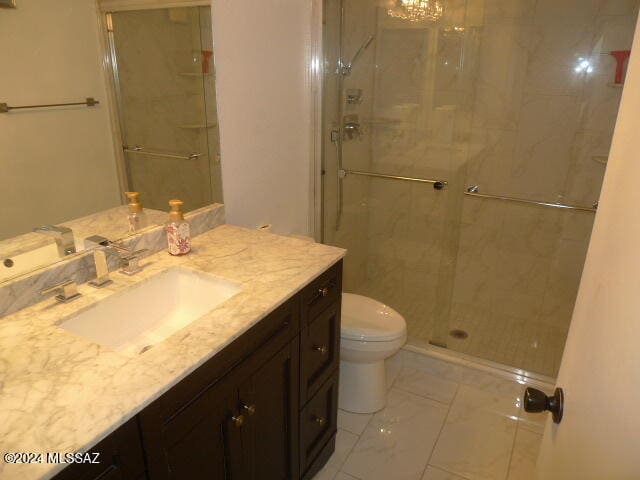 bathroom featuring an enclosed shower, vanity, and toilet