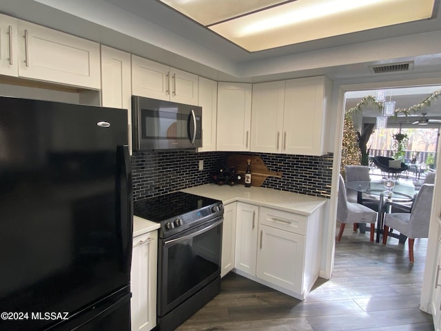 kitchen with white cabinets, appliances with stainless steel finishes, and dark hardwood / wood-style flooring