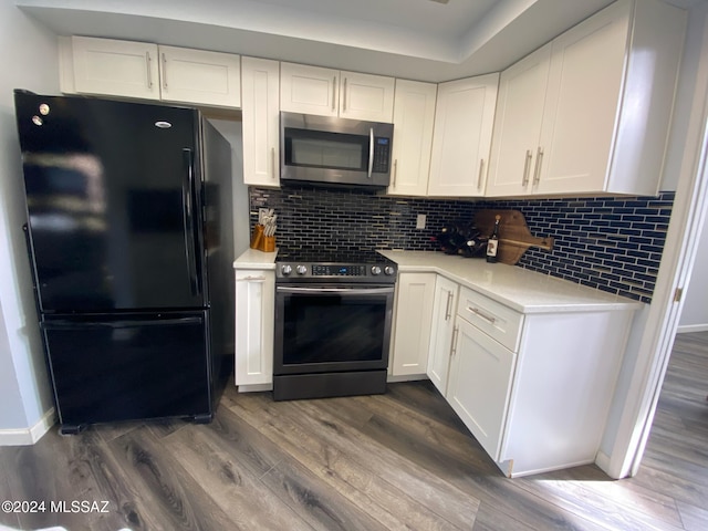 kitchen with stainless steel appliances, dark hardwood / wood-style floors, and white cabinetry