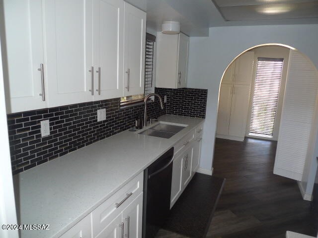 kitchen featuring dishwasher, sink, dark hardwood / wood-style flooring, and white cabinetry