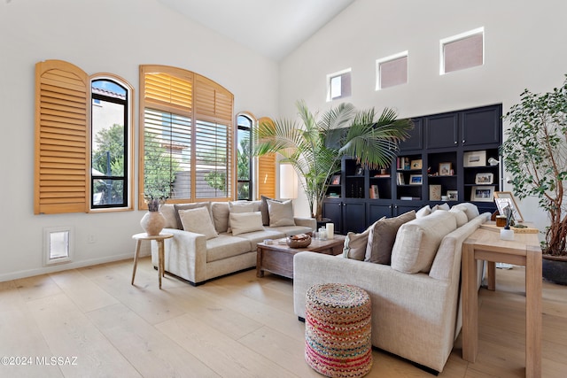 living room featuring light wood-type flooring and high vaulted ceiling