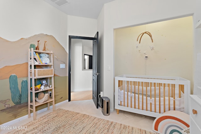 bedroom with a nursery area and light colored carpet