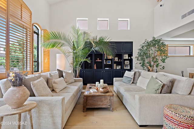 living room featuring light hardwood / wood-style floors and high vaulted ceiling