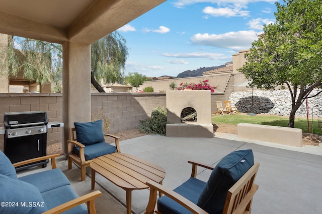 view of patio with an outdoor fireplace and area for grilling