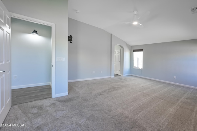 carpeted spare room with vaulted ceiling