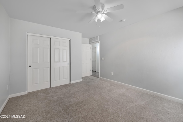 unfurnished bedroom with a closet, light colored carpet, and ceiling fan