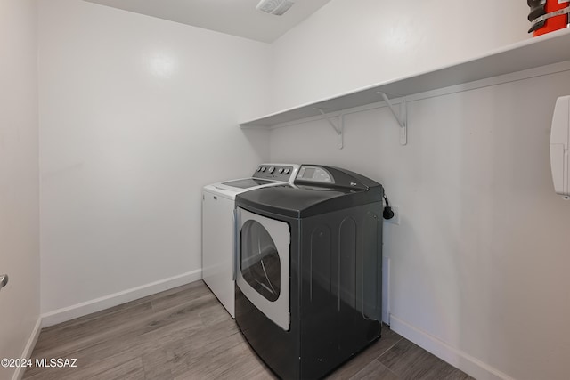 laundry area featuring wood-type flooring and washer and clothes dryer