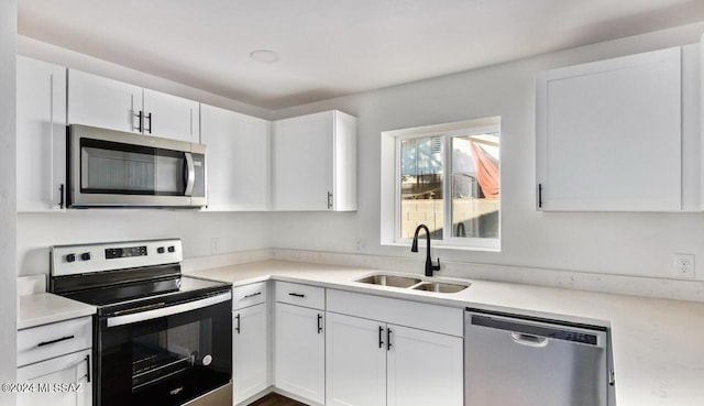 kitchen featuring white cabinetry, appliances with stainless steel finishes, light countertops, and a sink