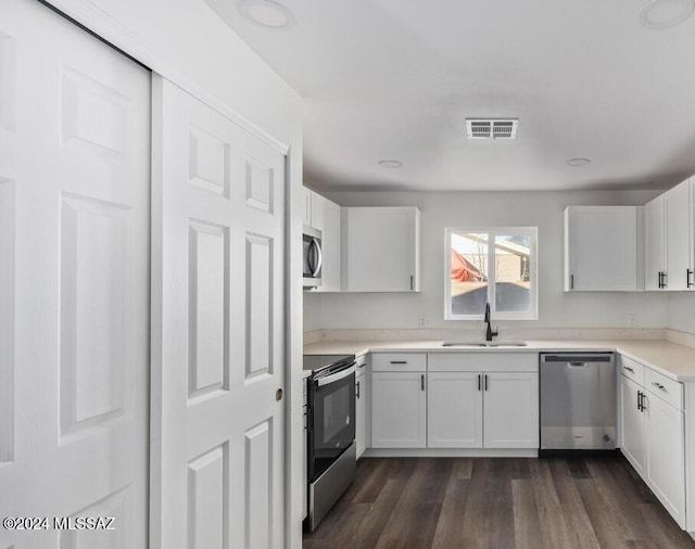 kitchen featuring a sink, visible vents, white cabinetry, appliances with stainless steel finishes, and dark wood finished floors