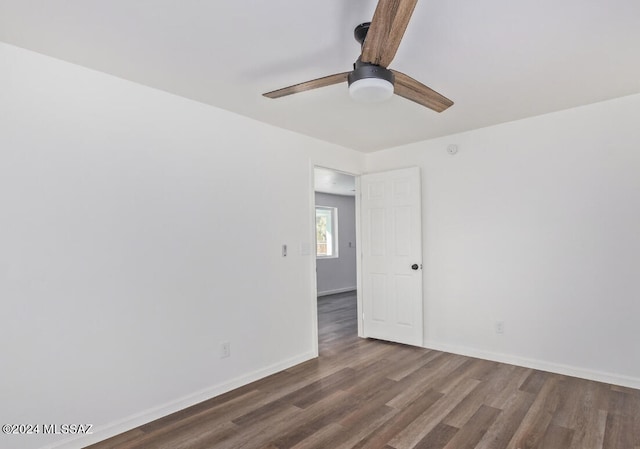 spare room featuring wood finished floors, a ceiling fan, and baseboards