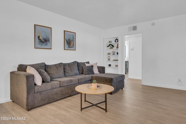 living room featuring light hardwood / wood-style flooring and built in features