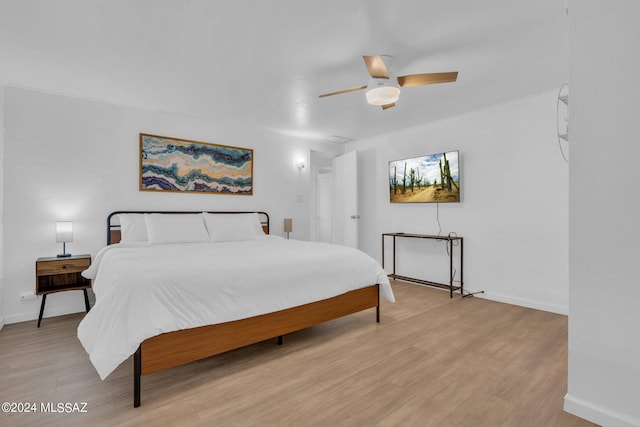 bedroom with light hardwood / wood-style floors and ceiling fan