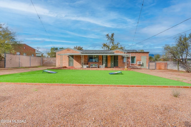 back of house featuring a yard and covered porch