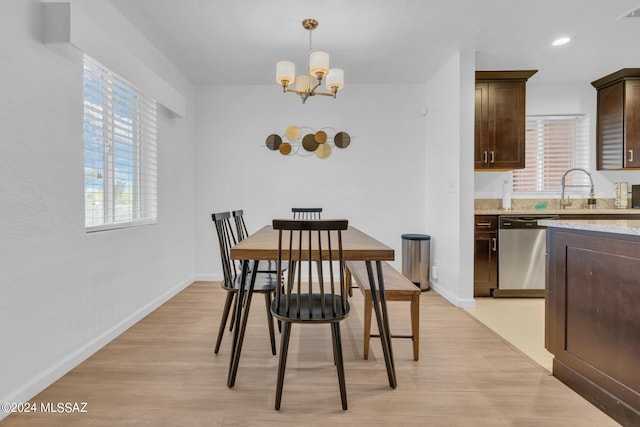 dining area featuring a notable chandelier, light wood-type flooring, and sink