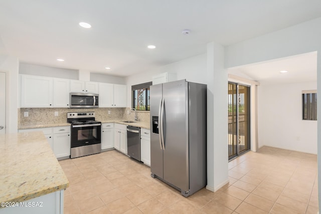 kitchen featuring tasteful backsplash, sink, light stone counters, white cabinets, and appliances with stainless steel finishes