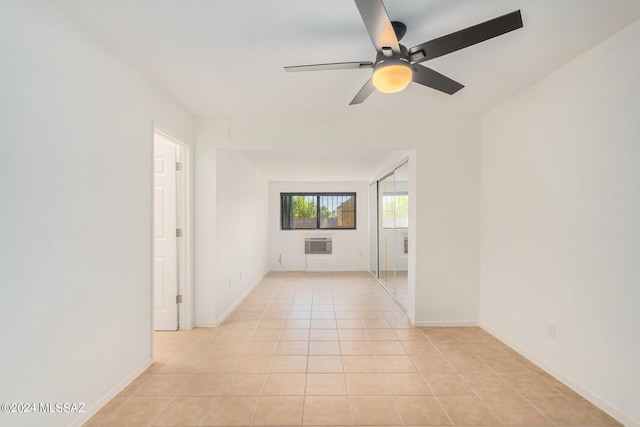 empty room featuring light tile patterned flooring, ceiling fan, and an AC wall unit