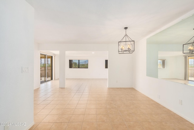 unfurnished room featuring light tile patterned flooring and a chandelier