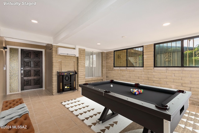 game room with a wall unit AC, beamed ceiling, brick wall, billiards, and light tile patterned floors