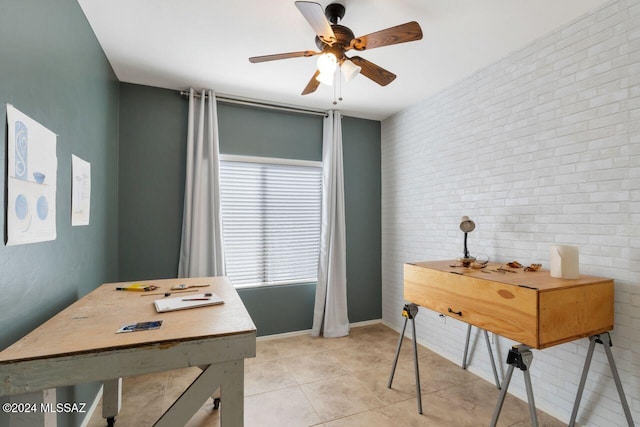 tiled office space featuring brick wall and ceiling fan