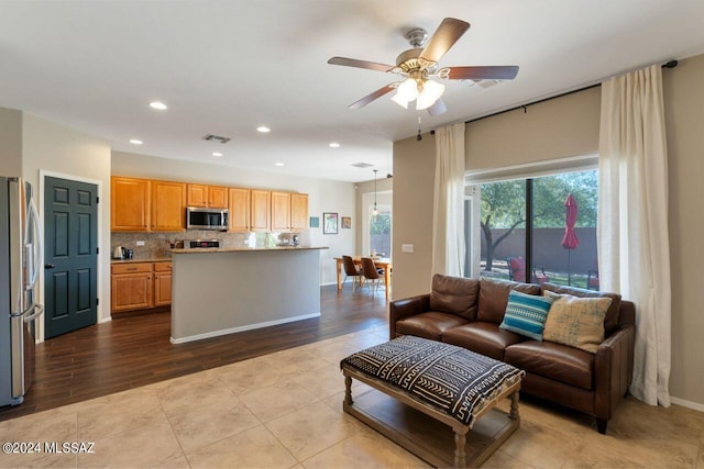 living room featuring light tile patterned floors and ceiling fan