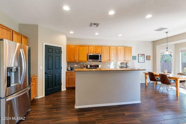 kitchen featuring decorative backsplash, stainless steel appliances, dark hardwood / wood-style flooring, and hanging light fixtures