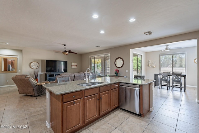 kitchen featuring dishwasher, plenty of natural light, sink, and an island with sink