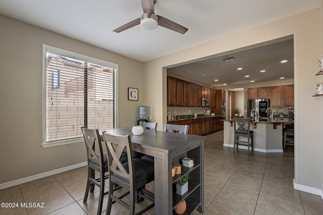 tiled dining space featuring ceiling fan