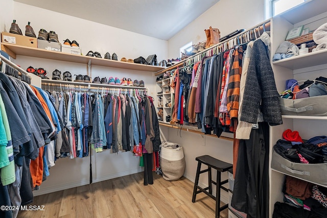 walk in closet with light hardwood / wood-style floors