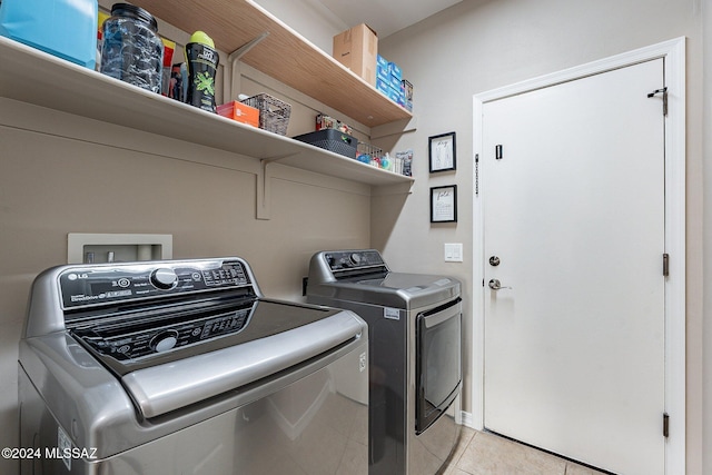 laundry room featuring washing machine and dryer and light tile patterned floors