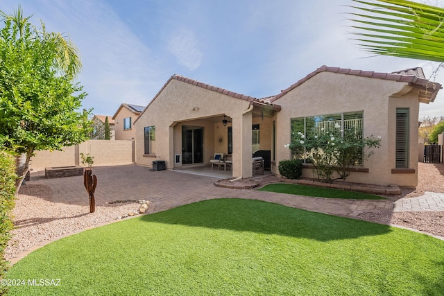 back of house with ceiling fan and a patio area