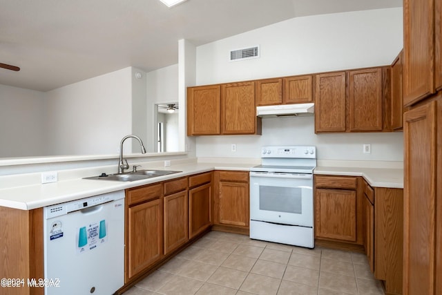 kitchen with lofted ceiling, white appliances, sink, kitchen peninsula, and light tile patterned floors