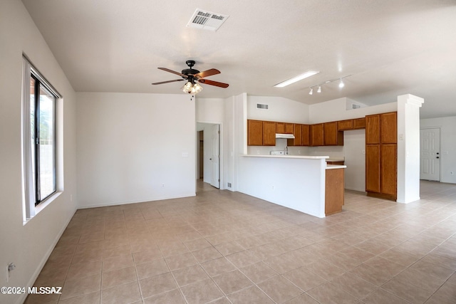 kitchen with ceiling fan, light tile patterned floors, kitchen peninsula, rail lighting, and vaulted ceiling