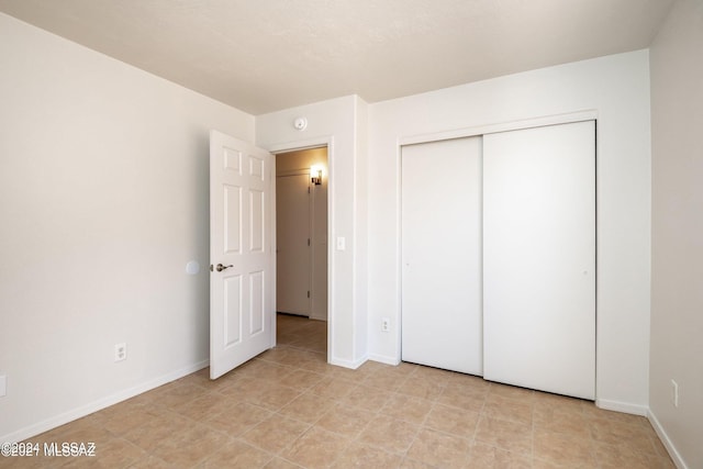 unfurnished bedroom with light tile patterned flooring and a closet