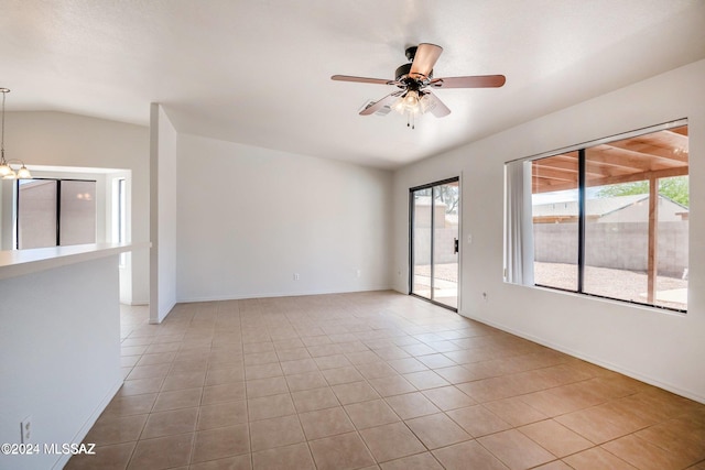 tiled empty room with ceiling fan with notable chandelier and lofted ceiling