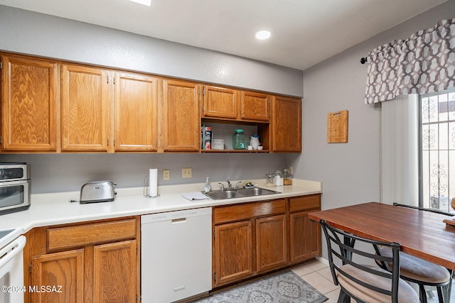 kitchen featuring white appliances, sink, and light tile patterned floors