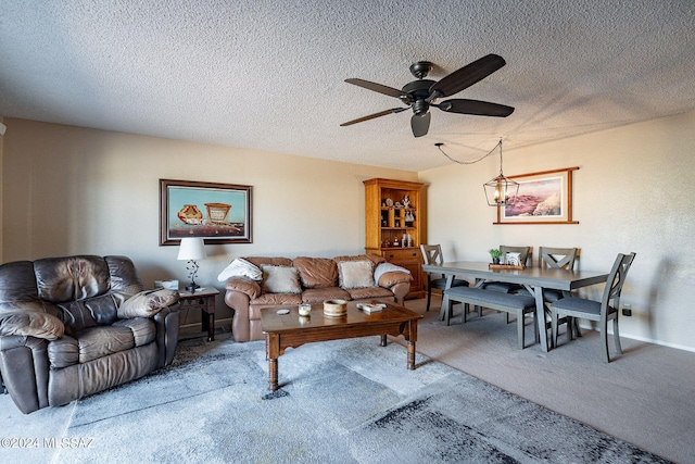 living room featuring ceiling fan, a textured ceiling, and carpet flooring