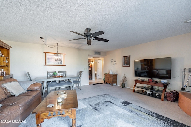 living room featuring light carpet, a textured ceiling, and ceiling fan with notable chandelier