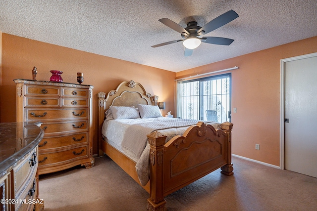 carpeted bedroom with ceiling fan and a textured ceiling