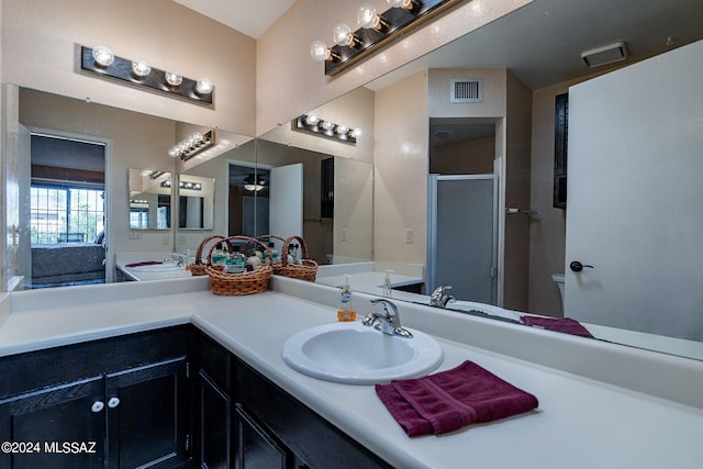 bathroom featuring vanity, toilet, and a shower with door