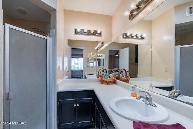 bathroom with vanity and a shower with door