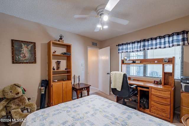 bedroom with ceiling fan and a textured ceiling