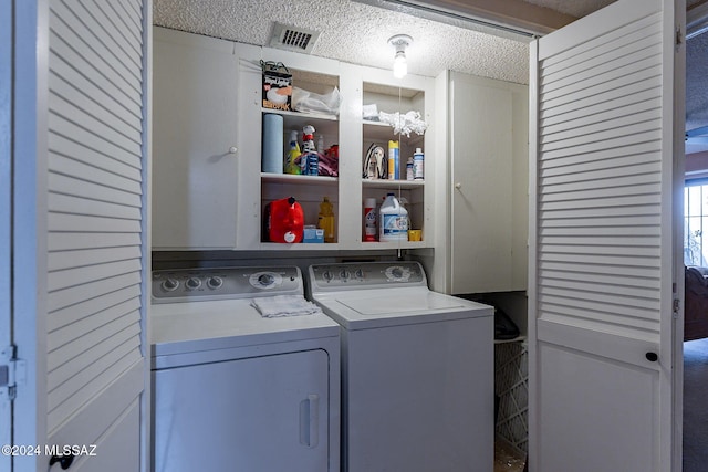 washroom featuring an inviting chandelier, a textured ceiling, and independent washer and dryer