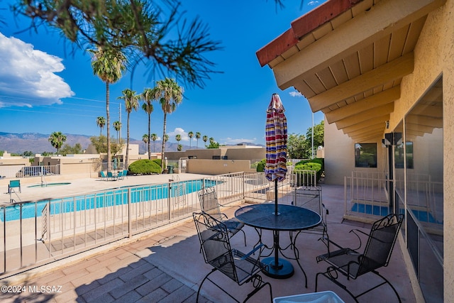 view of swimming pool with a mountain view and a patio